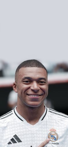 a man in a soccer uniform smiling for the camera