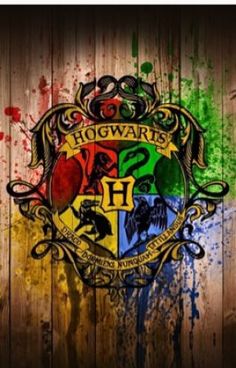 the hogwart's crest is painted on a wooden wall with paint splatters