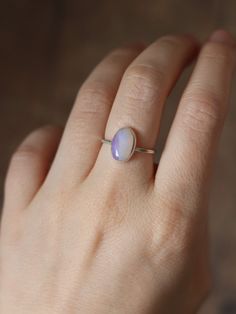 This dainty and extremely delicate ring features a beautiful Australian Lightning Ridge opal, set in a fine silver bezel with open back. The band is made with a sterling silver square wire. Size 6Handmade It's a perfect everyday ring - simple, yet full of character. Can be stacked and combined with other rings or worn by itself, for a more minimalist look. Delicate purples make each opal absolutely unique, with its own stunning colours and inclusions. The look of the gemstone changes in differen Delicate Sterling Silver Opal Ring, Delicate Silver Opal Ring In Sterling Silver, Minimalist Opal Stackable Promise Rings, Minimalist Adjustable Opal Ring, Minimalist Adjustable Opal Open Ring, Dainty Stackable Sterling Silver Opal Ring, Minimalist Opal Rings With Gemstone, Minimalist Opal Birthstone Ring, Minimalist Oval Opal Ring For Gift