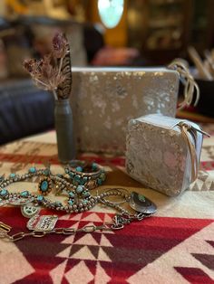 a table topped with jewelry and a vase filled with flowers