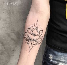 a woman's arm with a lotus tattoo on the left side of her arm