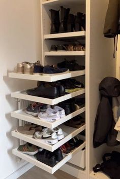 a closet with several shelves and shoes on the bottom shelf in front of an open door