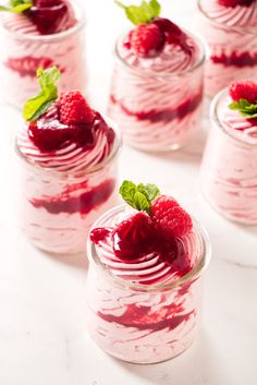 raspberry trifle in small glass jars with mint leaves on top