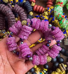 This handcrafted bracelet features Ghanaian Krobo Region recycled sugar crust beads, and African brass beads crafted through the time-honored "lost wax" technique. Its stretchy design and unique irregularities testify to its artisanal origin, making each a one-of-a-kind creation. Recycled sugar crust glass beads  100% Ashanti Brass Beads Bohemian Purple Beaded Bracelets With Large Beads, Handmade Artisan Pink Beaded Bracelet, Handmade Heishi Beads Bangle Bracelet, Purple Faceted Beads Bracelets For Festivals, Purple Faceted Beads Bracelet For Festivals, Purple Faceted Beaded Bracelets For Festivals, Unique Purple Bracelets With Round Beads, Handmade Beaded Bangle Bracelet For Healing, Handmade Purple Beaded Bangle Bracelet