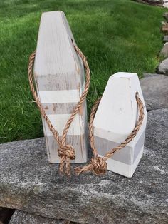 two pieces of wood tied together on top of a stone slab with grass in the background