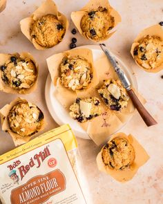 blueberry muffins are sitting on a plate next to a bag of almond flour