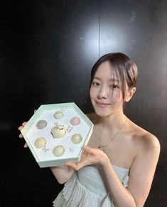 a young woman holding up a box of jewelry