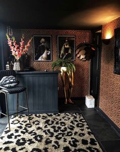 a living room with pictures on the wall and a rug in front of a bar