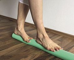 a person standing on a yoga mat with their feet propped against the wall behind them