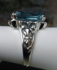 <> #144 {Made To Order} Inspired by Gothic designs, I now offer this lovely filigree inspiration in sterling silver. This is a flawless Man-made/simulated aquamarine is 15mm (5/8th of an inch) by 12mm (1/2 inch) in size. The inside of the band is etched 925. Notice the intricate and detailed Victorian design of the antique patina silver filigree setting all the way down the band. This is an exquisite rendition of an antique filigree ring.... and is ready to wear. A gift-box is included for Victorian Hallmarked Blue Topaz Jewelry, Victorian Style Hallmarked Blue Topaz Jewelry, Victorian Blue Topaz Hallmarked Jewelry, Classic Filigree Blue Topaz Rings, Heirloom Blue Topaz Diamond Cut Jewelry, Anniversary Jewelry With Engraved Blue Topaz, Formal Engraved Sapphire Jewelry, Formal Blue Engraved Ring Hallmarked, Formal Blue Topaz Filigree Jewelry