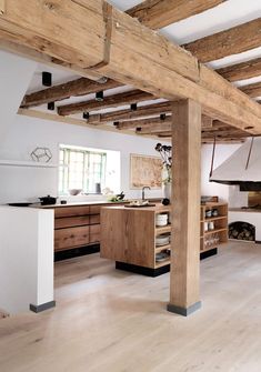 an instagramted photo of a kitchen with wood floors and exposed beams on the ceiling