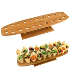 a wooden tray with several small sandwiches on it and another serving platter in the background