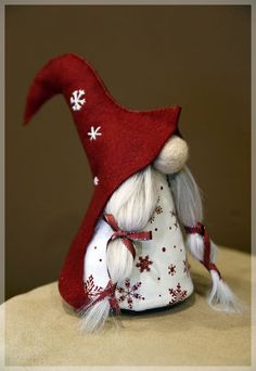 a red and white christmas gnome sitting on top of a table