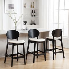 two black and white chairs sitting in front of a counter