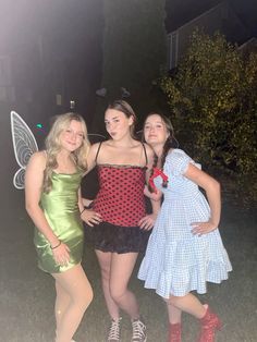 three girls dressed up as tinkerbells posing for the camera