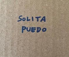 the word solita puedo is written in blue ink on a brown surface