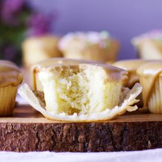 cupcakes with frosting and sprinkles sitting on a cutting board