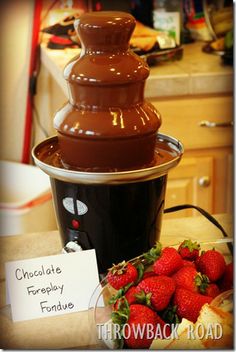 chocolate fondant fountain with strawberries in bowl on kitchen counter next to sign that says chocolate fondant