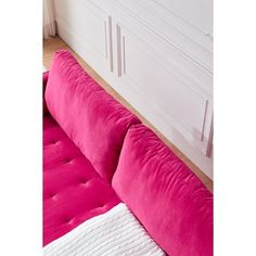 a fuchsia pink couch with white pillows