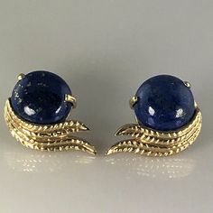 Exquisite 14 karat yellow gold earrings, set with two lapis lazuli cabochons, each measuring approximately 11.92 millimeters (0.47 inches) in diameter by 4.85 millimeters (0.19 inches) deep, and each weighing an estimated 5.12 carats. Each earring measures approximately 26.5 millimeters (0.876 inches) long by 15.42 millimeters (0.607 inches) wide, and the pair together weighs 7.52 grams. They are unmarked, but acid tested positive as 14 karat gold and do not react to a magnet. Like many estate e Yellow Gold Lapis Lazuli Jewelry With Polished Finish, Polished Yellow Gold Lapis Lazuli Jewelry, Formal Yellow Gold Jewelry With Lapis Lazuli, Formal Yellow Gold Lapis Lazuli Jewelry, Yellow Gold Lapis Lazuli Cabochon Jewelry, Classic Lapis Lazuli Yellow Gold Jewelry, Classic Yellow Gold Lapis Lazuli Jewelry, Classic Yellow Gold Jewelry With Lapis Lazuli, Gold Pierced Earrings With Lapis Lazuli