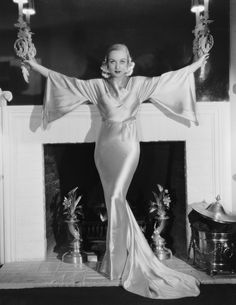 a woman standing in front of a fire place with her arms spread out and hands outstretched