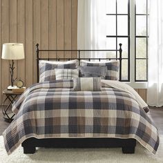 a black and white checkered comforter set on a bed with brown leather chair