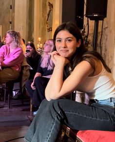 a woman sitting on top of a chair in front of a crowd