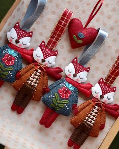 four red and blue ornaments are hanging on a piece of paper with silverware in the shape of hearts