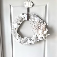 a white wreath hanging on the front door