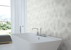 a white bath tub sitting under a window next to a wall mounted faucet