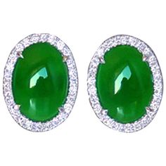 Featuring a pair of Beautiful Oval Cabochon cut Natural Jadeite Jade measuring approx. 13.48 x 10.06 x 4.18mm; 4.71 ct and 13.49 x 10.49 x 4.02mm; 4.56 ct; total 9.27ct, vivid green; Burma, (N) Type A = not enhanced; FTIR-tested; (A-Jade)(certificate GRS); each earring surrounded by, 52 round brilliant cut Diamonds, total 0.71 ct, quality G-H / VS-SI; total 104 round brilliant cut Diamonds; Hand crafted in 18k white gold; prong set. Classic and Timeless! Diamond Gold Earrings, Yellow Gold Diamond Earrings, Vintage Stud Earrings, Round Diamond Setting, 18k Gold Earrings, Fantasy Closet, Gold Statement Earrings, Jade Earrings, Gold Diamond Earrings