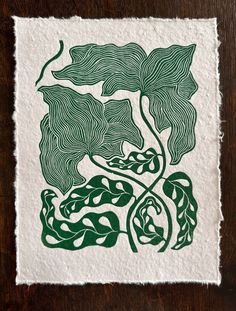 a green and white drawing on top of a piece of paper next to a wooden table