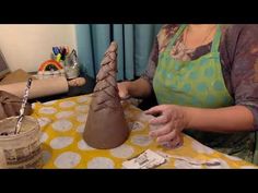 a woman is working with clay on a table