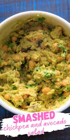 a bowl filled with mashed chickpea and avocado salad on top of a blue table