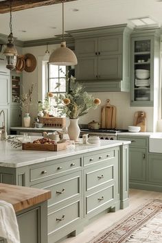 a kitchen filled with lots of green cupboards and counter top space next to a window