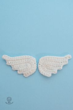 two crocheted angel wings on a blue background