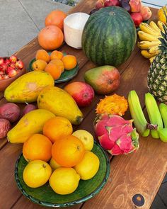 a table topped with lots of different types of fruit on top of a wooden table