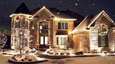 a house covered in christmas lights and wreaths with snow falling on the ground next to it