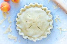 an uncooked pie sitting on top of a table next to other fruits and vegetables