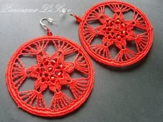 red crochet earrings with beads on the bottom and an intricate design in the middle