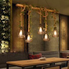 the restaurant is decorated with greenery and hanging light fixtures, along with wooden tables