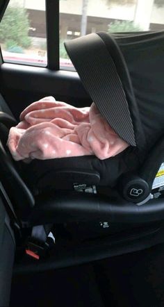 an infant car seat with a blanket on it's back in the passenger side