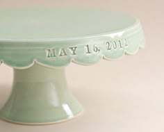 a green cake plate with scalloped edges and the date may 16, 2012