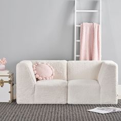 a white couch sitting on top of a carpet covered floor