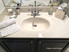 a bathroom sink with soap, toothbrushes and other items on the counter top