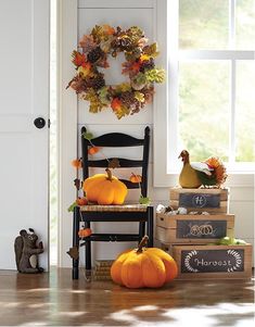 pumpkins and gourds sit on the floor in front of a door