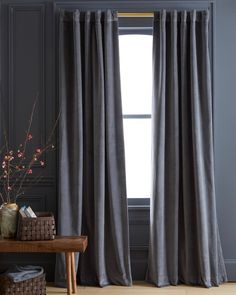 the curtains in this room are made from dark gray linen and have a long drape