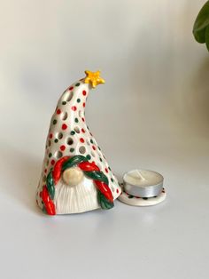 a ceramic christmas hat next to a candle holder