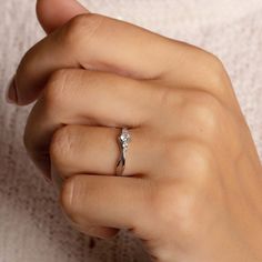 a woman's hand with a diamond ring on it