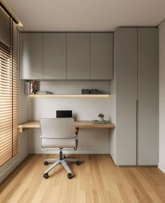 an office area with a desk, chair and cupboards in the corner is shown